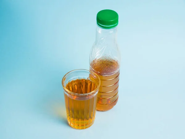 Segelas Jus Dan Botol Plastik Dengan Latar Belakang Kertas Biru — Stok Foto