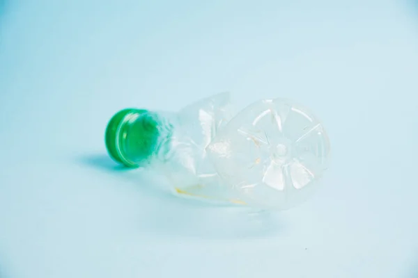 stock image Used plastic bottle of juice for a drink on a blue background. Concept of earth day, zero waste and plastic recycling