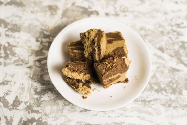 Açık gri arkaplanda beyaz bir tabakta kakaolu nefis bir helva..