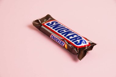 Ukrayna, Chernihiv, 26 Nisan 2023: Pembe arka planda Snickers çikolatası.