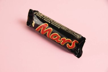 Ukrayna, Chernihiv, 26 Nisan 2023: Pembe arka planda Mars çikolatası.