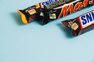 Ukrayna, Chernihiv, 26 Nisan 2023: Mavi arka planda lezzetli Mars ve Snickers çikolataları.