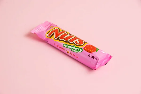 stock image Ukraine, Chernihiv, April 26, 2023: Nuts chocolate bar with strawberries on a pink background.