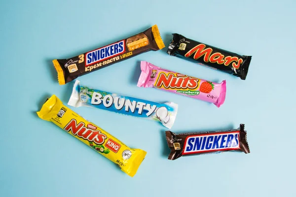 stock image Ukraine, Chernihiv, April 26, 2023: Many delicious chocolate bars in a package, Bounty, Mars, Snickers and Nuts bars on a blue background.