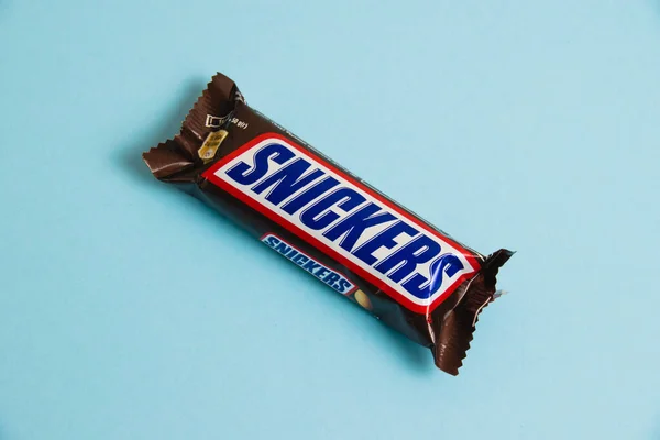 乌克兰 切尔尼赫夫 2023年4月26日 美味的Snickers巧克力棒 里面有蓝色背景的花生 — 图库照片