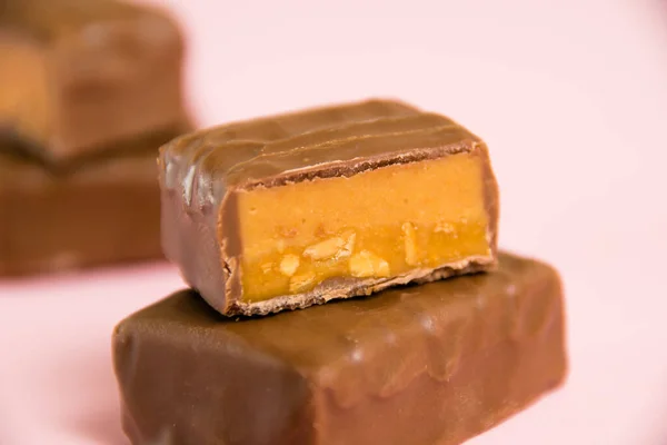 Barra Chocolate Doce Com Macro Caramelo Salgado Fundo Papel Rosa — Fotografia de Stock