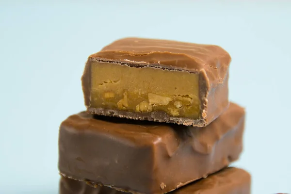 Deliciosas Barras Chocolate Con Caramelo Salado Sobre Fondo Papel Azul —  Fotos de Stock
