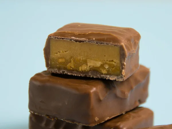 Deliciosas Barras Chocolate Com Caramelo Salgado Fundo Papel Azul — Fotografia de Stock