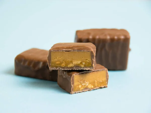 Deliciosas Barras Chocolate Com Caramelo Salgado Fundo Papel Azul — Fotografia de Stock