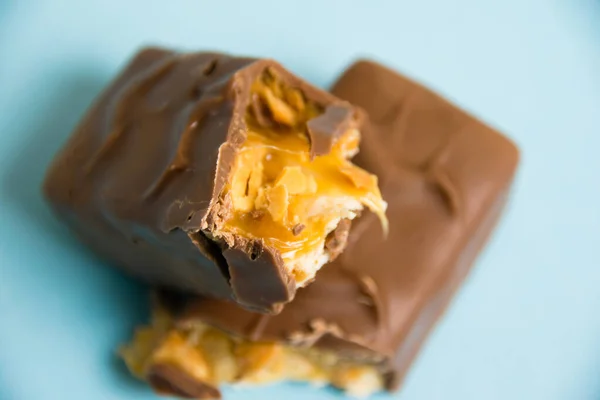 Deliciosas Barras Chocolate Con Turrón Cacahuetes Sobre Fondo Azul —  Fotos de Stock