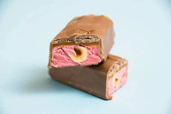 Chutná Čokoládová Tyčinka Celými Lískovými Oříšky Jahodami Modrém Pozadí — Stock fotografie