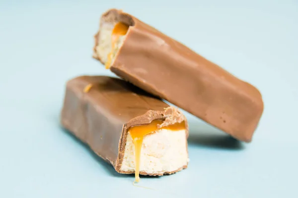 Sabrosa Barra Chocolate Con Turrón Blanco Caramelo Sobre Fondo Azul —  Fotos de Stock