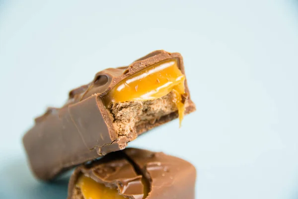 Pedaços Apetitosos Uma Barra Chocolate Com Macro Caramelo Fundo Azul — Fotografia de Stock
