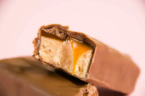 Pedaços Barra Chocolate Apetitoso Com Caramelo Macro Nougat Fundo Rosa — Fotografia de Stock