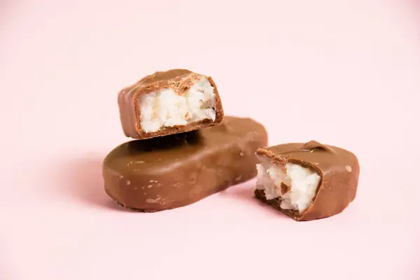 Barra Chocolate Doce Com Flocos Coco Macro Fundo Papel Rosa — Fotografia de Stock