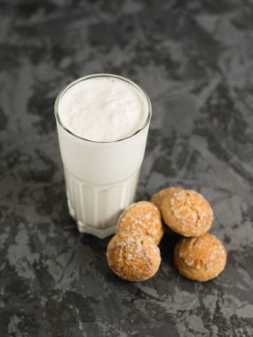 Lezzetli, ferahlatıcı bir yaz içeceği, süt ve dondurmadan yapılmış bir milkshake. Siyah bir masada zencefilli ekmek..