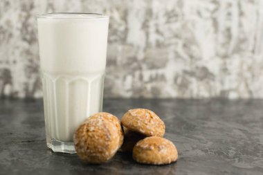 Lezzetli, ferahlatıcı bir yaz içeceği, süt ve dondurmadan yapılmış bir milkshake. Siyah bir masada zencefilli ekmek..