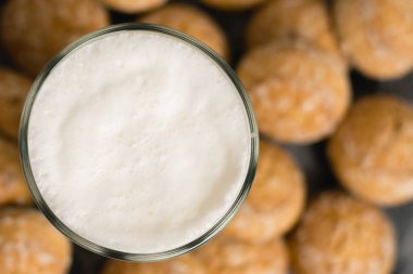 Flatlay, bir bardakta nefis, ferahlatıcı bir yaz içeceği, süt ve dondurmadan yapılmış bir milkshake. Tatlı köpüklü kokteyl yakın plan. Siyah bir masada zencefilli ekmek..