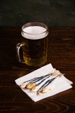 Bira bardağında nefis hafif bira ve arka planda kurutulmuş balık..