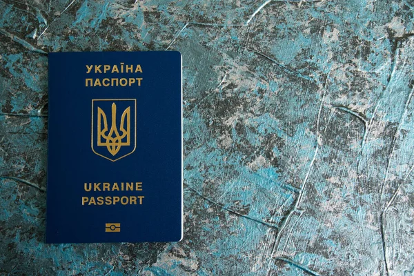 Foreign passport of a Ukrainian on a dark background with copy space. The concept of Ukrainians going abroad to earn money.