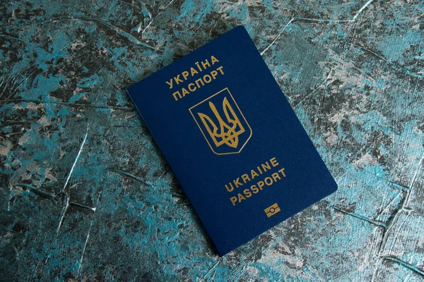 Foreign passport of a Ukrainian on a dark background with copy space. The concept of Ukrainians going abroad to earn money.