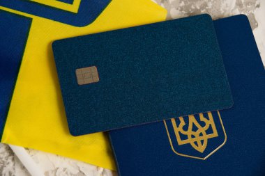 Flatlay, yakın çekimli kredi kartı Ukrayna pasaportu ve ışık masasında bayrak.