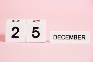 Noel, 25 Aralık tarihli ahşap takvim pembe arka planda. Noel ve Yeni Yıl Kutlama Konsepti