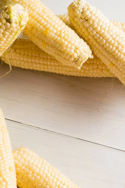 Flatlay, delicious, sweet white corn on light table close-up, copy space background.