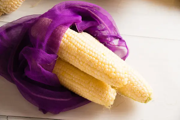 Appetizing sweet corn on the table in an eco bag for vegetables and fruits. Concept of conservation of ecology