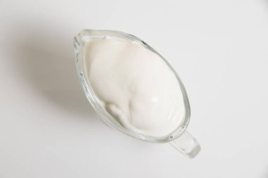 Beyaz arka planda cam tabakta ekşi krema..