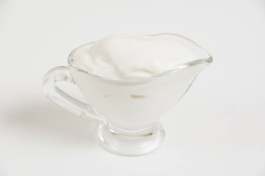 Beyaz arka planda cam tabakta ekşi krema..