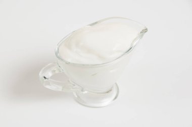 Beyaz arka planda cam tabakta ekşi krema..