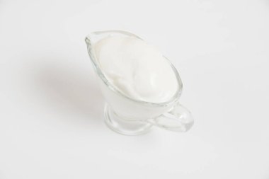 Beyaz arka planda cam tabakta ekşi krema..