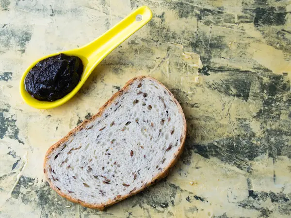 Flatlay, fındıklı çikolata ezmesi ve arka planda susamlı beyaz ekmek. Kalori ve abur cubur kavramı