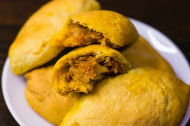 Koyu ahşap bir masada lahana kaplı nefis ev yapımı turtalar..