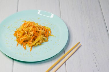 Lezzetli Kore mutfağı. Havuçlu salata ve turkuaz bir tabakta Kore usulü daikon.