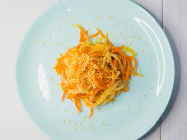 Lezzetli Kore mutfağı. Havuçlu salata ve turkuaz bir tabakta Kore usulü daikon.