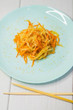 Lezzetli Kore mutfağı. Havuçlu salata ve turkuaz bir tabakta Kore usulü daikon.