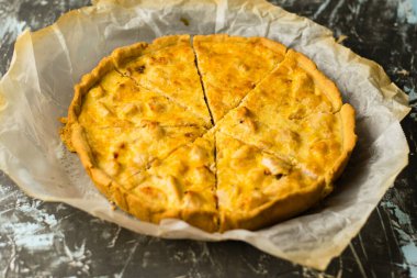 Tavuk ve peynirli lezzetli Fransız kiş turtası. Pasta pişirme işlemi parşömen üzerinde soğutma