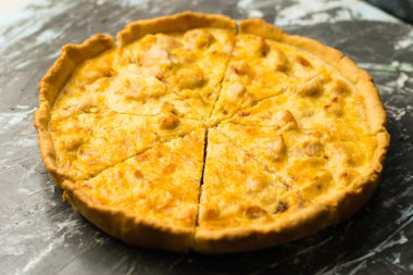 Tavuklu ve peynirli nefis Fransız kiş turtası, metin ve fotokopi alanı olan karanlık bir arka planda. Gıda blogu kavramı, yazma tarifleri.