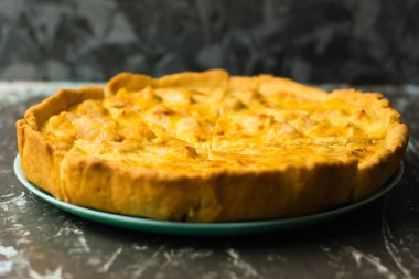 Tavuklu ve peynirli nefis Fransız kiş turtası, metin ve fotokopi alanı olan karanlık bir arka planda. Gıda blogu kavramı, yazma tarifleri.