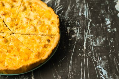 Tavuklu ve peynirli nefis Fransız kiş turtası, metin ve fotokopi alanı olan karanlık bir arka planda. Gıda blogu kavramı, yazma tarifleri.