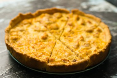 Tavuklu ve peynirli nefis Fransız kiş turtası, metin ve fotokopi alanı olan karanlık bir arka planda. Gıda blogu kavramı, yazma tarifleri.