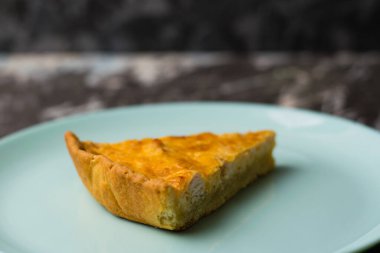 Turkuaz bir tabakta tavuk, peynir ve kremayla birlikte nefis bir dilim turta, fotokopi alanı. Yemek blogu konsepti, tarif yazımı