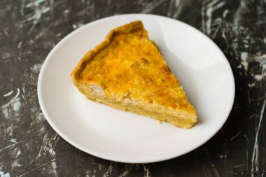 Flatlay, beyaz bir tabakta tavuk, peynir ve kremalı açık yüzlü kiş turtası. Yemek blogu kavramı, yemek tarifleri