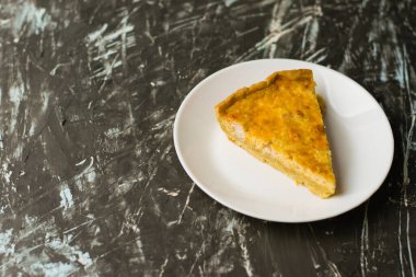 Flatlay, beyaz bir tabakta tavuk, peynir ve kremalı açık yüzlü kiş turtası. Yemek blogu kavramı, yemek tarifleri