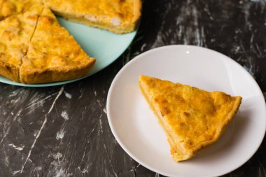 Flatlay, beyaz bir tabakta tavuk, peynir ve kremalı açık yüzlü kiş turtası. Yemek blogu kavramı, yemek tarifleri
