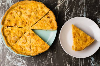 Flatlay, beyaz bir tabakta tavuk, peynir ve kremalı açık yüzlü kiş turtası. Yemek blogu kavramı, yemek tarifleri
