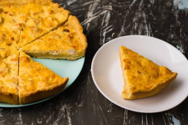 Flatlay, beyaz bir tabakta tavuk, peynir ve kremalı açık yüzlü kiş turtası. Yemek blogu kavramı, yemek tarifleri