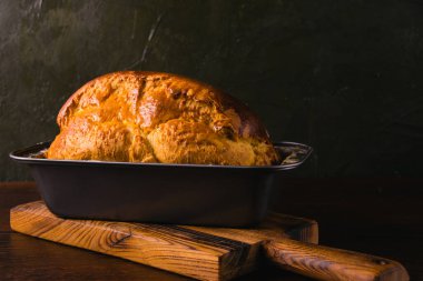 Ekmek pişirme tavasında tatlı çörekler, koyu bir arka planda. Lezzetli ev yapımı hamur işleri..